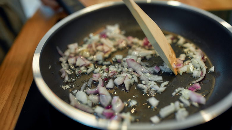 saute pan with onions and wooden spoon