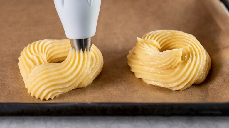 French cruller dough being piped