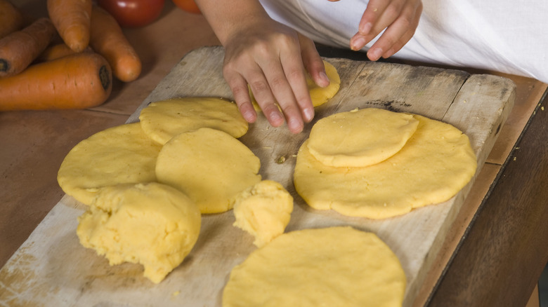 woman's hands making arepas