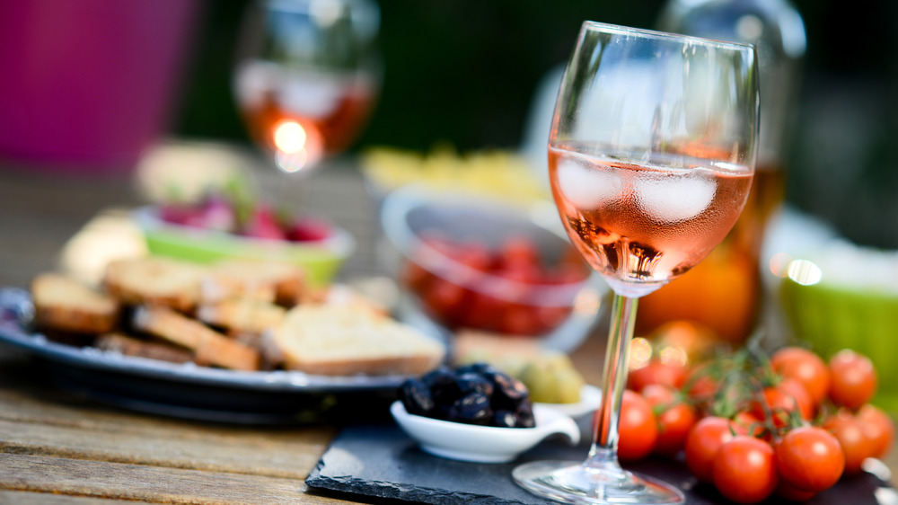 glass of rosé wine on table with ice cubes