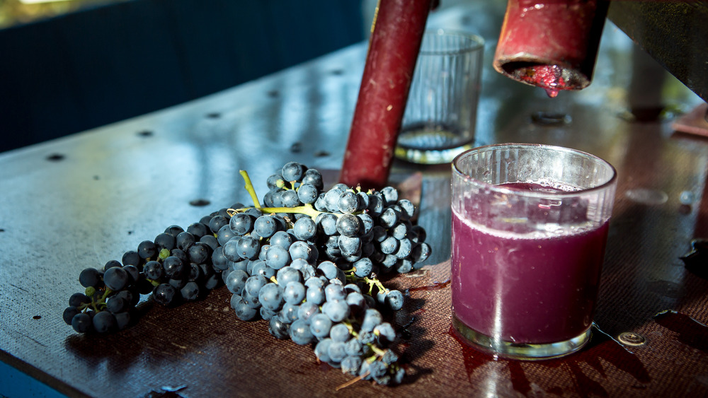 grapes next to glass of juice or wine