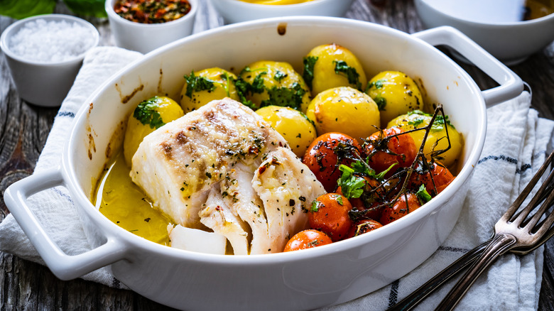 Fish and veggies in white roasting pan