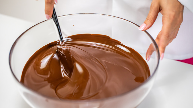 Hands stirring chocolate in bowl