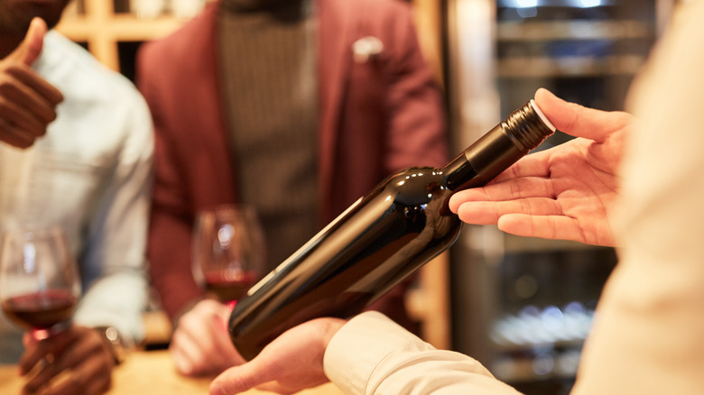 server presenting wine bottle