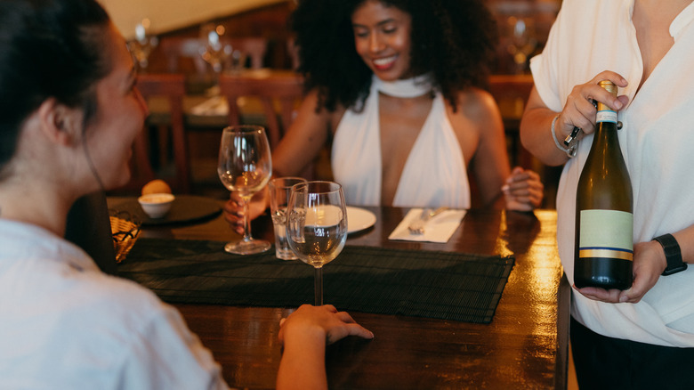 server holding wine bottle