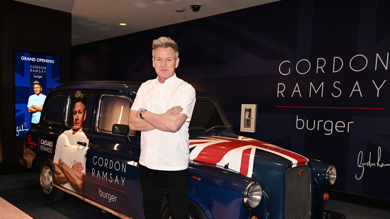 Gordon Ramsay standing in front of a car