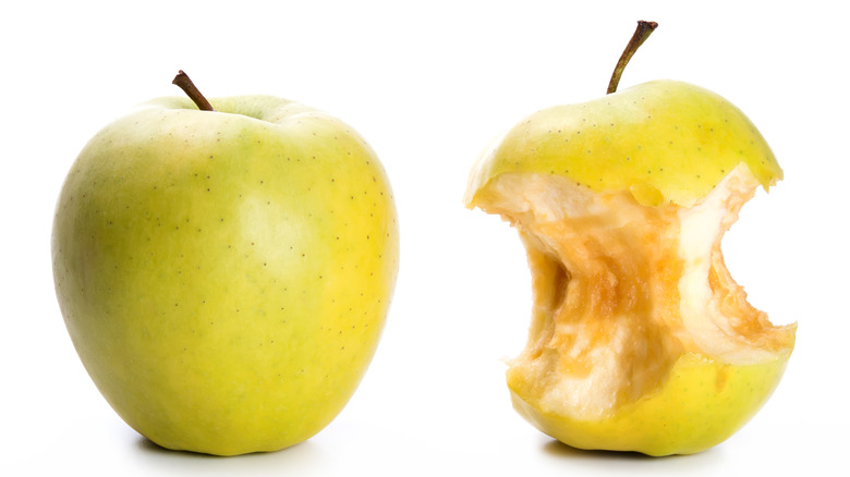 Oxidized apple with bites taken out next to a whole apple