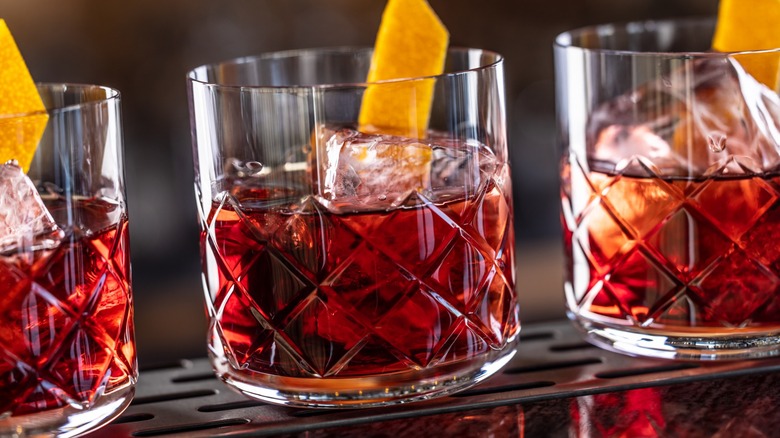 Three glasses of Negroni with orange twists