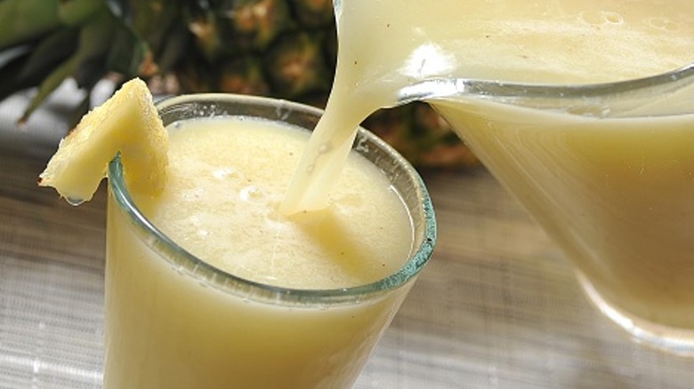 Close-up of a piña colada being poured into a glass