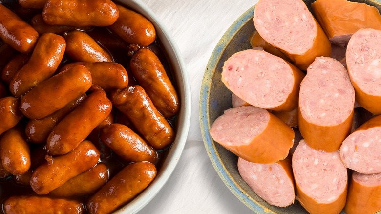 Dish of bratwurst beside a dish of sliced kielbasa