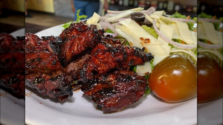 Marinated New England steak tips on a plate with salad