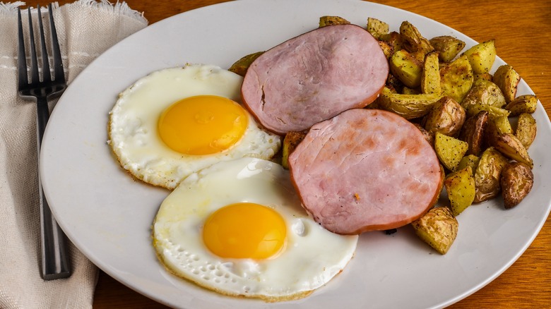 Fried eggs with home fries and Canadian bacon