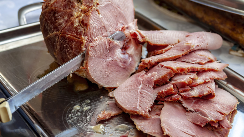 Roasted ham being sliced with an electric knife