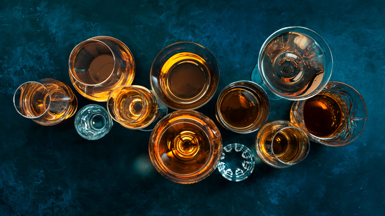 Glasses of liquor arranged on a dark blue surface