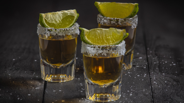 Three shots of añejo tequila with limes
