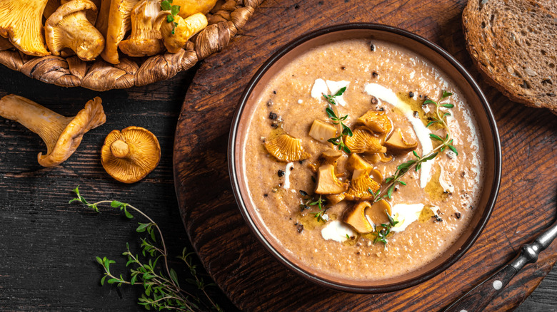 A bowl of mushroom soup on a wooden tray