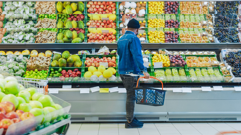 A grocery shopper in the produce section of a grocery store