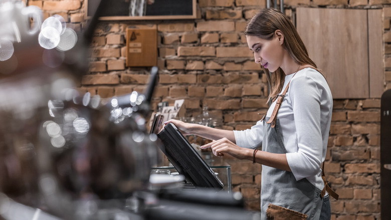 Waitress putting typing on screen