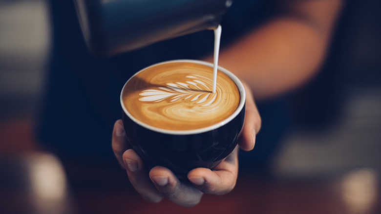 hands pouring latte art