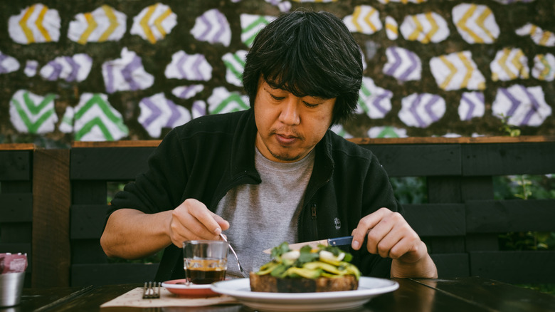 man eating in chile with cutlery