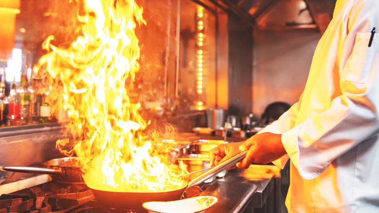 Chef flambéing in kitchen