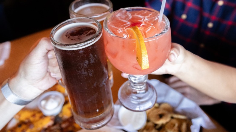 toasting cocktails over a table of food at Texas Roadhouse