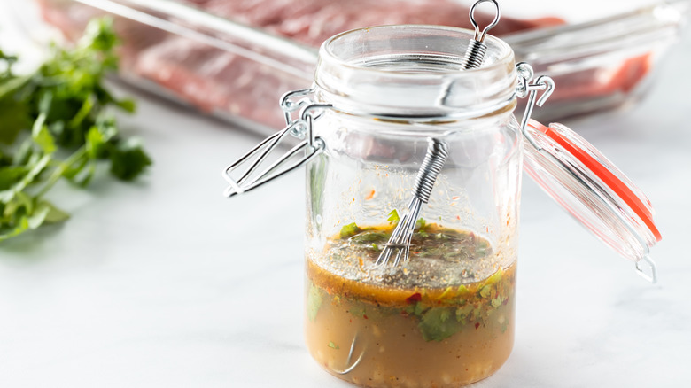 jar of marinade and whisk