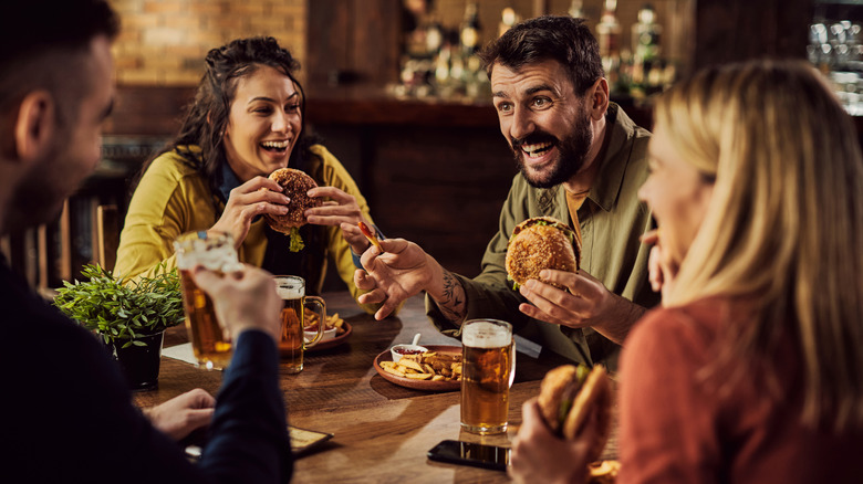 People having burgers and beer at restaurant