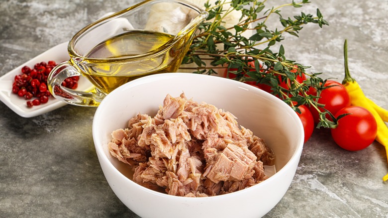 canned tuna in white bowl with surrounding ingredients