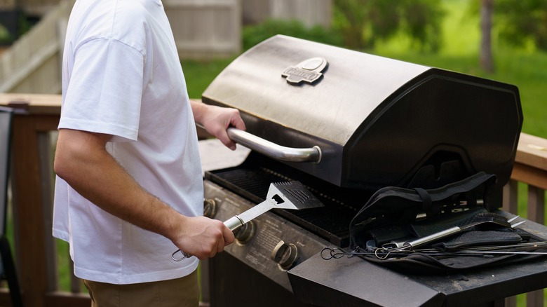 person grilling with lid closed