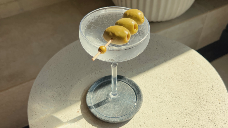 Dirty martini in a coupe glass on table