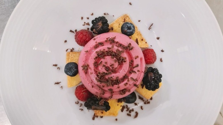 Pink dessert with fruits on white plate