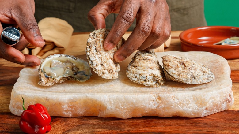 Hands shucking an oyster