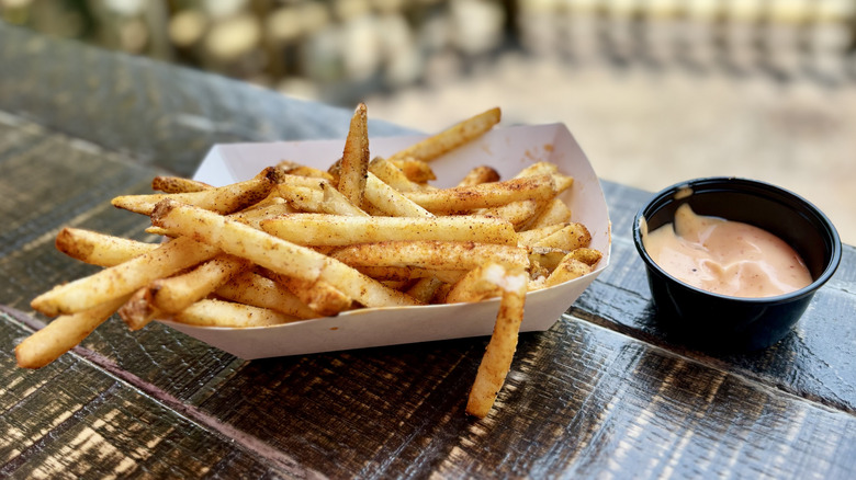 Mr. Kamal's Fries and sauce on wooden outdoor table