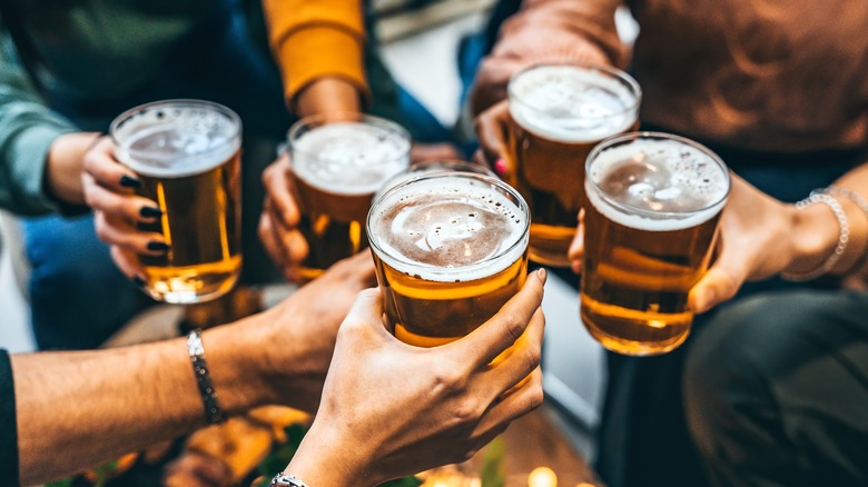 toasting glasses of beer at a brewery