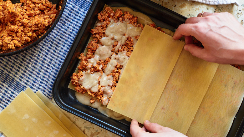 covering sauce with lasagna noodles