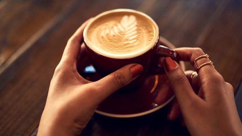 A person holding a coffee.