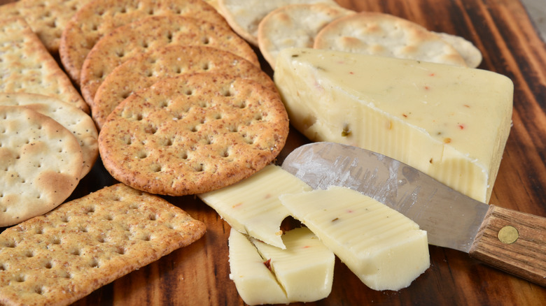 Pepper jack cheese paired with gourmet crackers on a cutting board