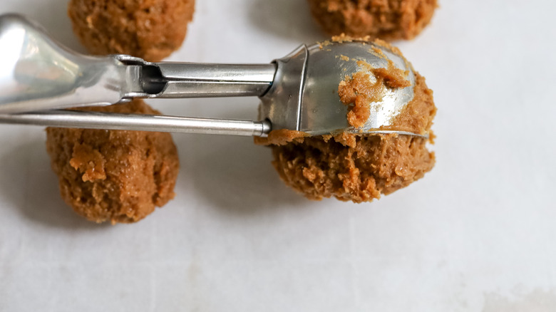 pumpkin spice truffle batter being scooped onto a pan