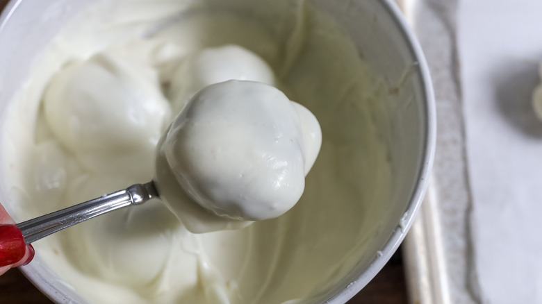 pumpkin spice truffles being dipped into white chocolate