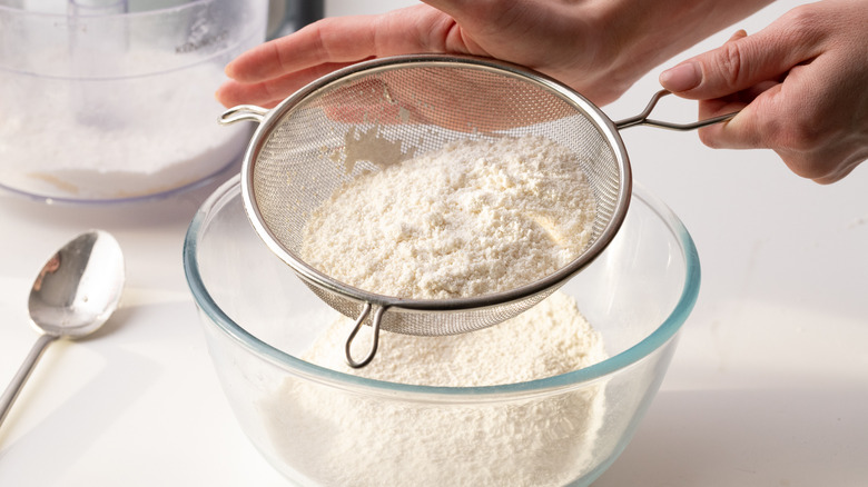 Sifting almond flour and sugar 