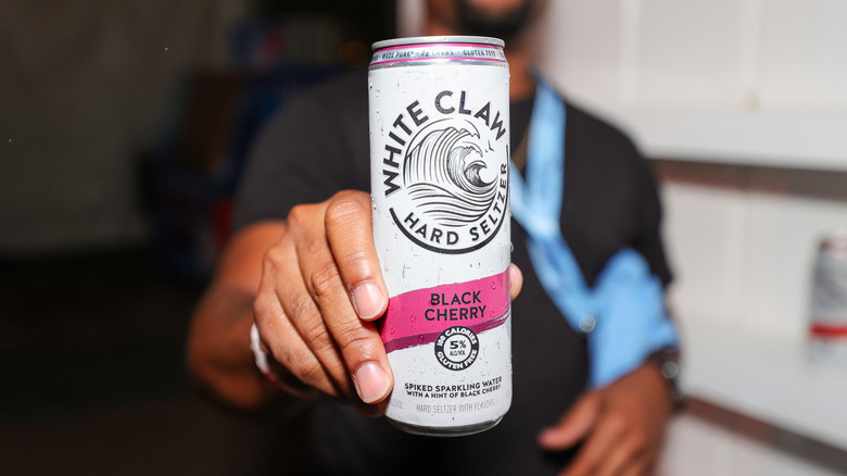 Person holding White Claw seltzer can