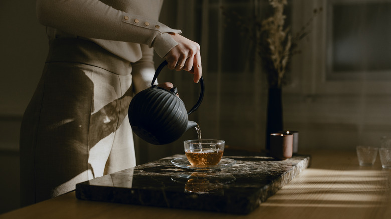 Person pouring teapot