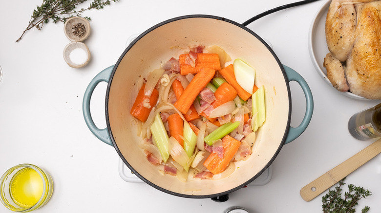Sauteing mixed vegetables and bacon in pot