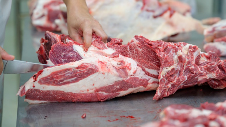 butcher trimming cuts of beef