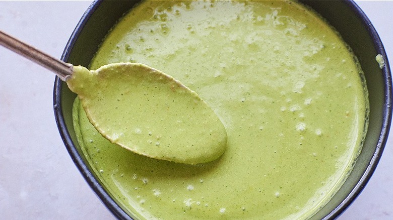 stirring aji verde sauce with spoon