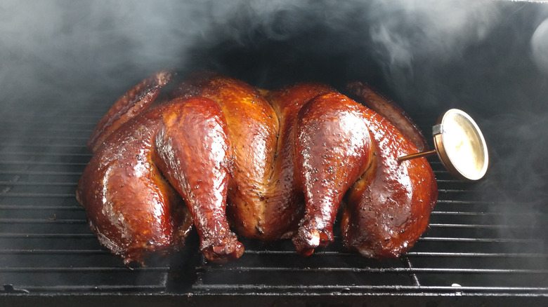 smoked turkey on a grill with a meat thermometer