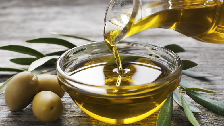 Olive oil being poured into a glass bowl