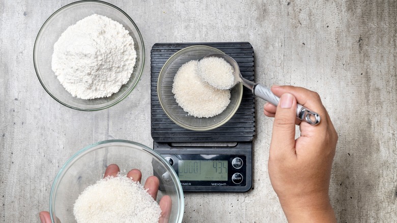 Person measuring sugar for cake