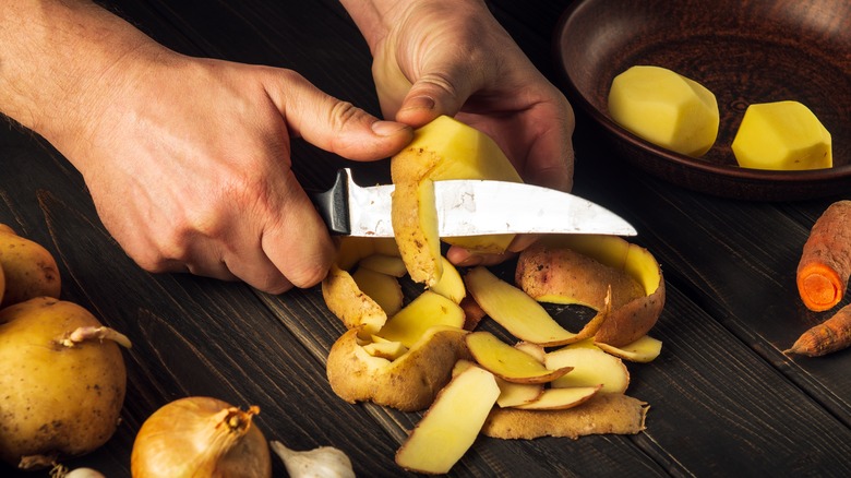 Hands cutting up potatoes